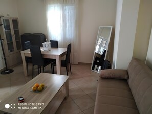 Um espaço compacto com mesa de jantar, cadeiras, sofá, armário e espelho.
