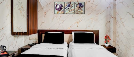 Habitación de hotel con dos camas, un armario de madera, una mesita de noche con un teléfono y una tetera, y una pared con diseño de mármol y una obra de arte enmarcada.