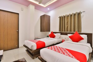 A hotel room with two beds, a wardrobe, a ceiling light, and a curtain. - Classic Hotel Navjivan (Ahmedabad)