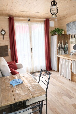 Un interior de madera con una mesa de comedor, sillas, un reloj y una planta.