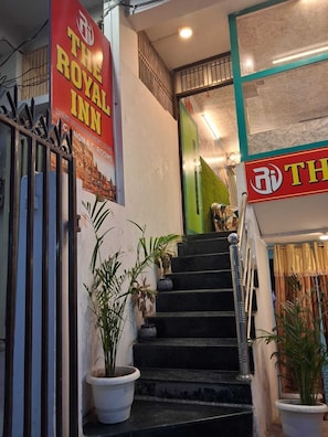 Una escalera conduce a la entrada de un hotel con un letrero que dice 'The Royal Inn' y un logotipo.