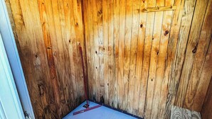 A room with wooden walls and a tiled floor, a ceiling fan, and a light fixture. - Camping Mairiporã (Mairiporã)