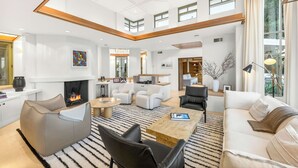 A spacious living area with a fireplace, modern furniture, and large windows. - Frank Lloyd Wright-Inspired Healdsburg Estate (Healdsburg)
