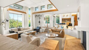 A spacious living area with a high ceiling, large windows, and a kitchen area with a fireplace. - Frank Lloyd Wright-Inspired Healdsburg Estate (Healdsburg)
