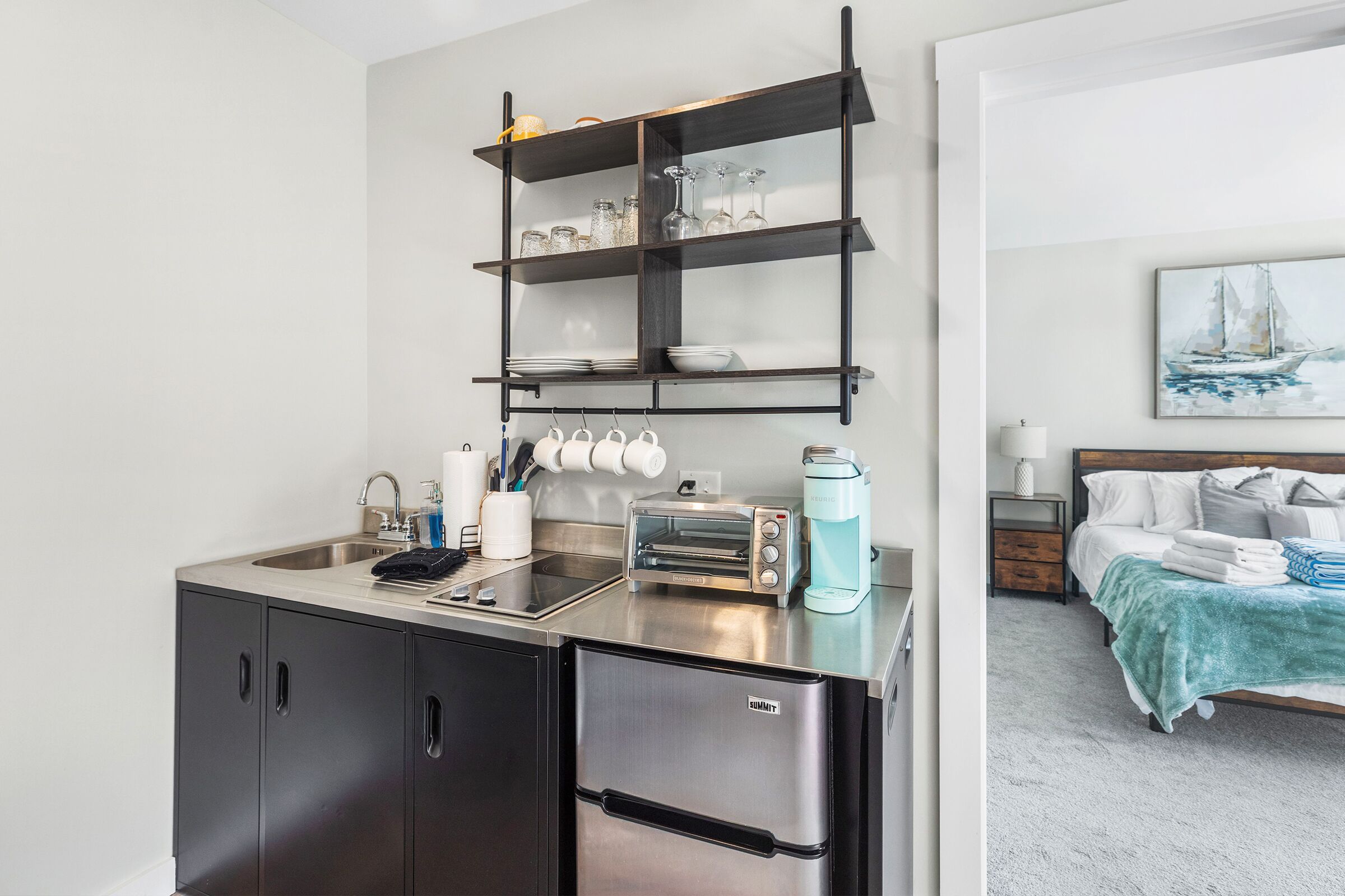 Eine kompakte Küchenzeile mit integriertem Backofen, Kaffeemaschine und Toaster.