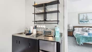 A compact kitchenette with a built-in oven, a coffee maker, and a toaster.