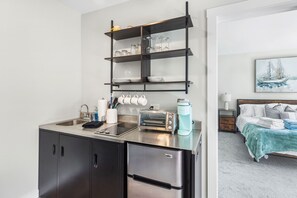 Uma cozinha compacta equipada com forno embutido, cafeteira e torradeira.