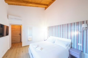 Ein Hotelzimmer mit Bett, Nachttisch, Lampe und einer gestreiften Wand.
