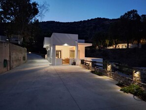 A modern house with a driveway, a stone wall, and a wooden fence. - VROMOLITHOS VIEW HOUSE: Your Stylish Getaway in Leros (Leros)
