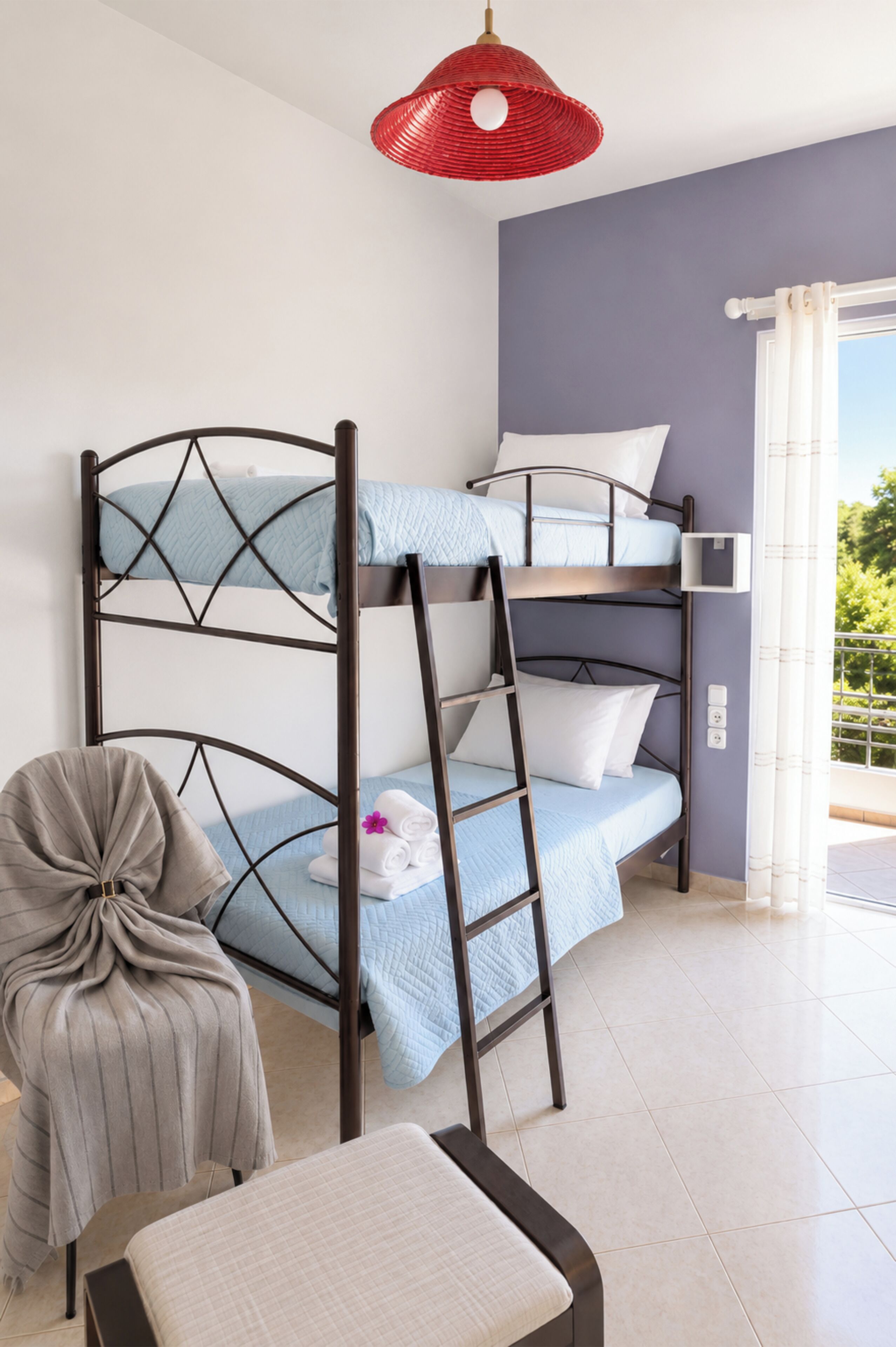 Una cama nido con escalera, una silla y una mesita en una habitación con vistas.