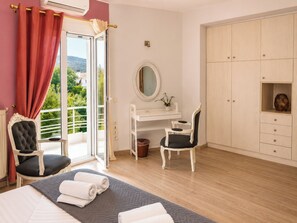 A bedroom with a bed, a desk, a chair, a wardrobe, and a balcony with a view. - Villa Morea With Pool Near Chania City (Chania)