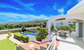 A modern outdoor area with a swimming pool, a patio with seating, and a view of the surrounding landscape. - Villa Morea With Pool Near Chania City (Chania)