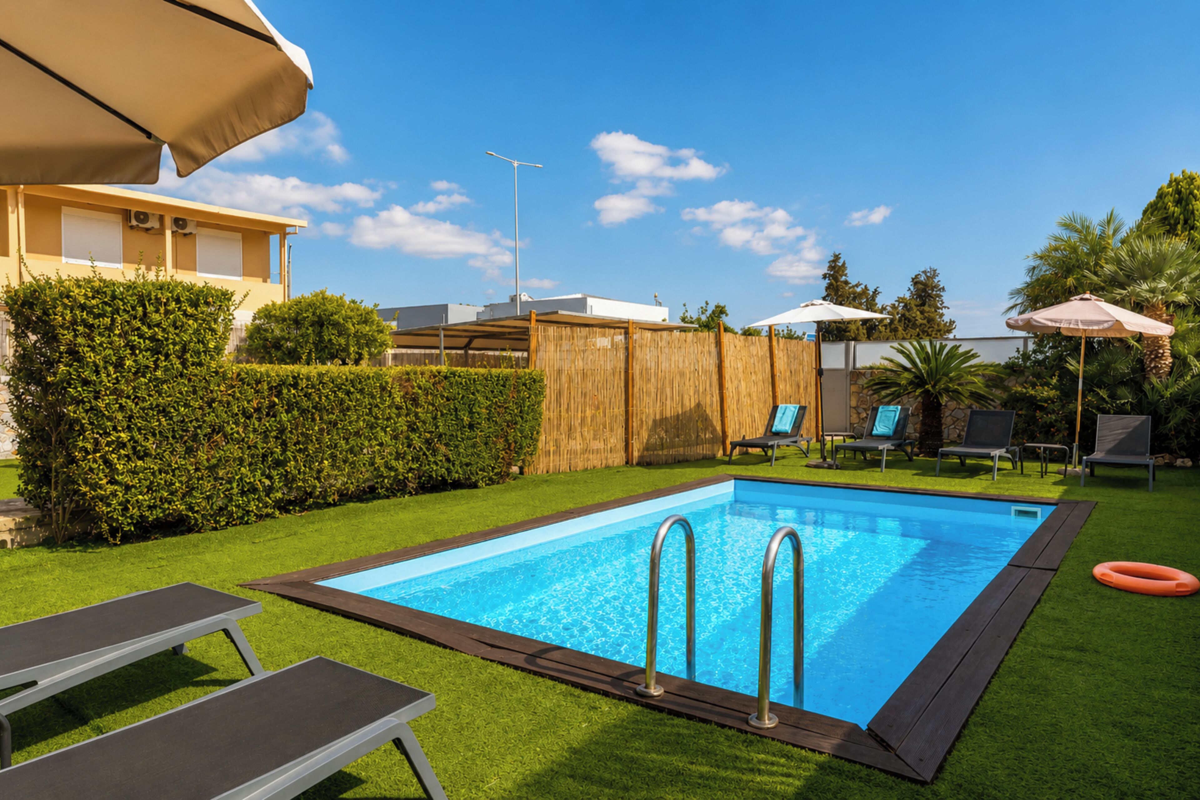 Departamento, vista al jardín | Alberca | Alberca al aire libre, sombrillas en la alberca y camastros 