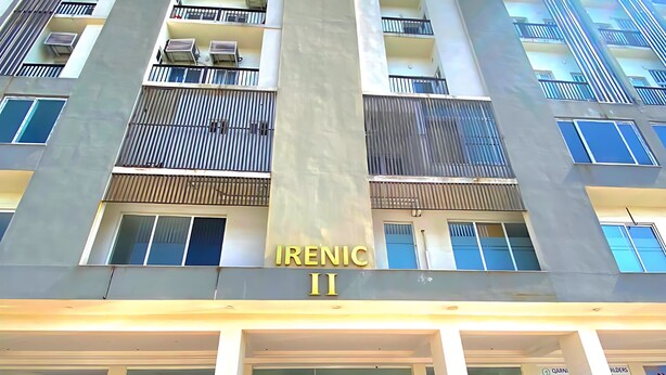 A multi-story building with the name 'Irenic II' on the facade, featuring balconies, windows, and a staircase leading to the entrance.