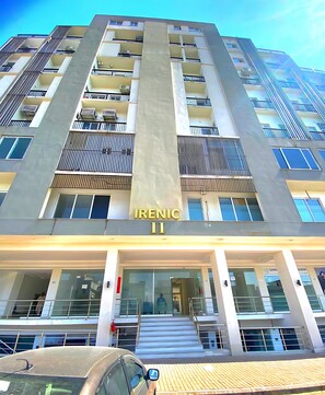 A multi-story building with the name 'Irenic II' on the facade, featuring balconies, windows, and a staircase leading to the entrance. - AAA Guest House (Bahria Town)