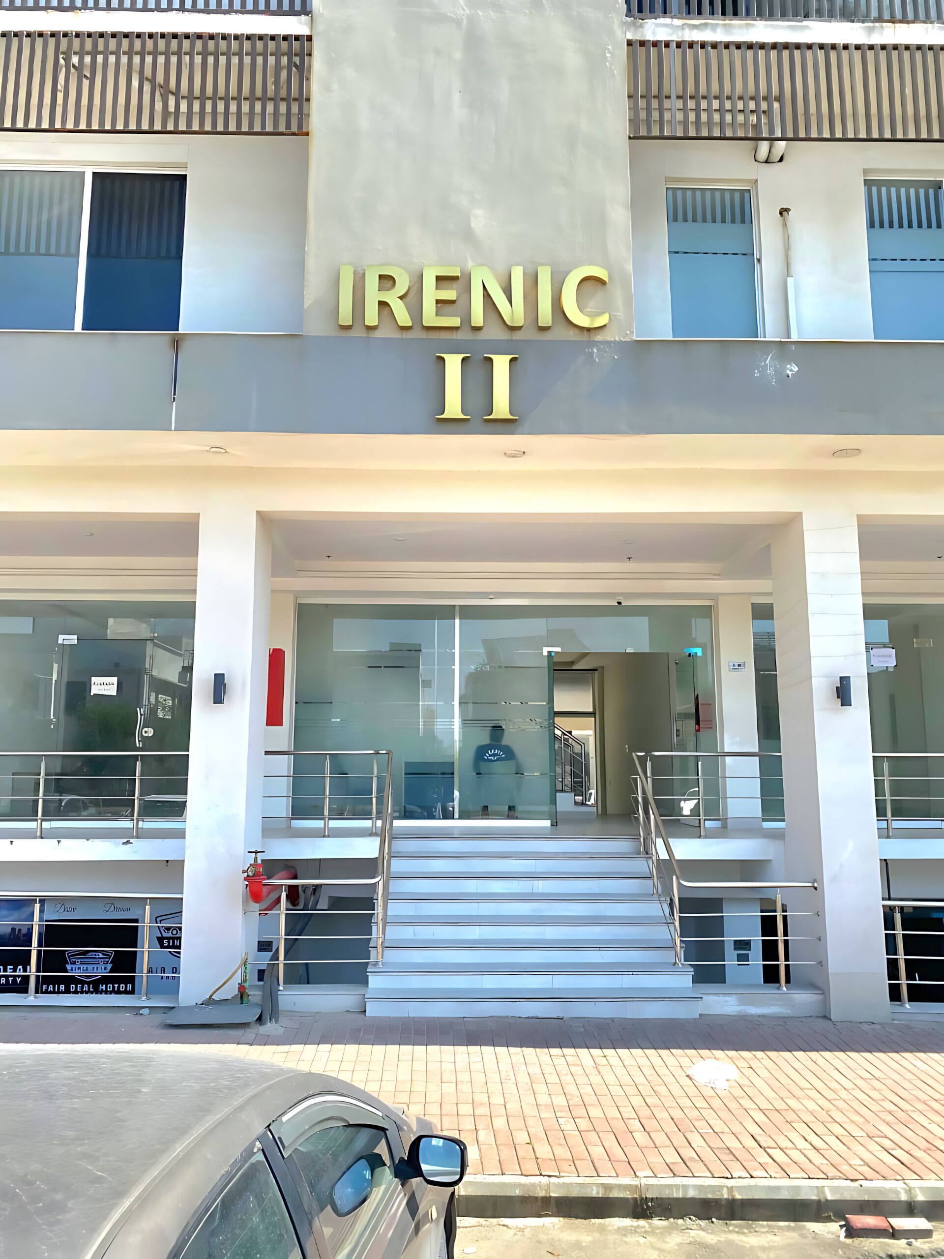 Un edificio con un letrero que dice 'Irenic II' y una escalera que lleva a la entrada.