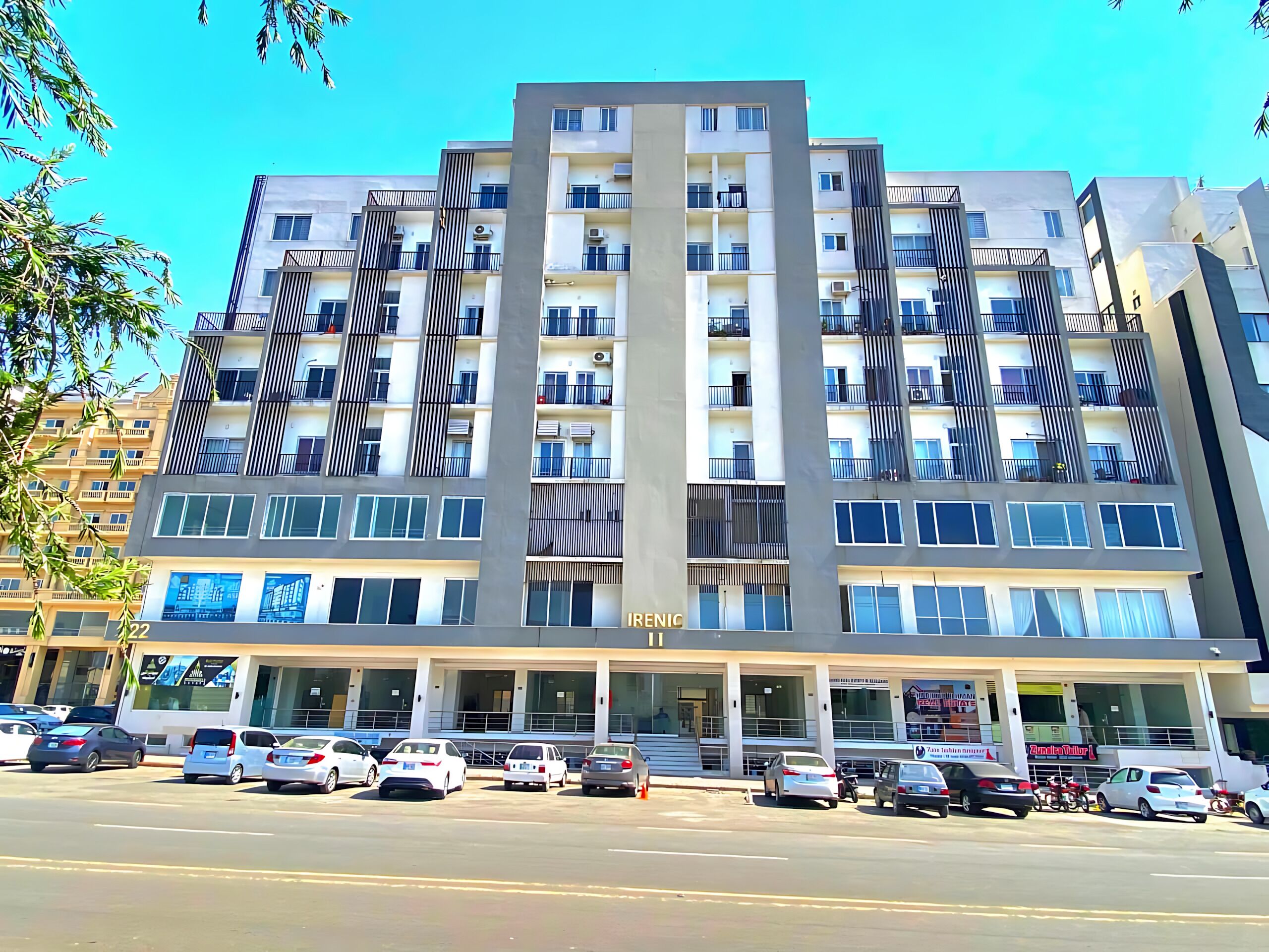 A multi-story hotel with a modern design, featuring balconies and a central entrance.
