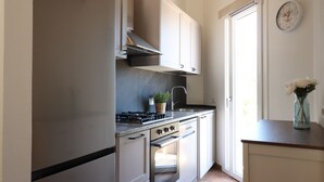 Een keuken met een kookplaat, oven en keukenkastjes.