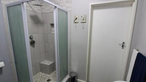 A bathroom with a glass-enclosed shower, a white toilet, and a bathtub. - Karoo Nest Calitzdorp (Calitzdorp)