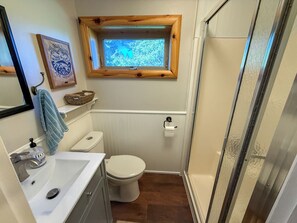 Een badkamer met toilet, wastafel en raam.
