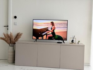 A television mounted on a cabinet with a woman playing the piano on the screen. - Mercury tower suites by Asignatures (St. Julian's)