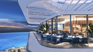 A modern hotel with a curved balcony overlooking the sea, featuring outdoor seating and a bar area. - Mercury tower suites by Asignatures (St. Julian's)