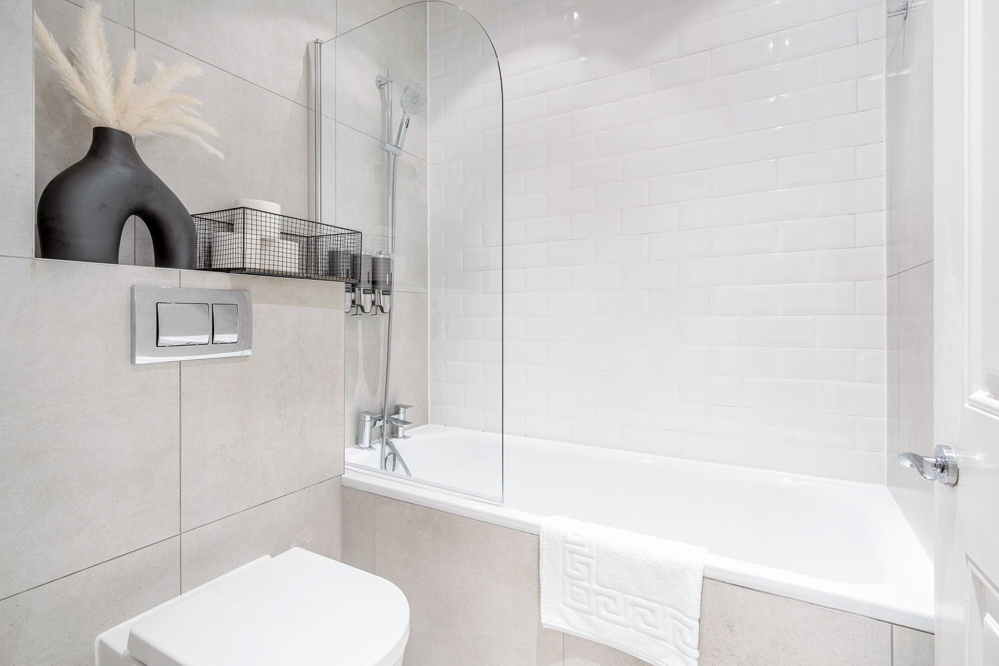 Une salle de bain moderne avec une baignoire blanche, des toilettes et un espace douche.