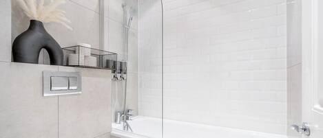 Une salle de bain moderne avec une baignoire blanche, des toilettes et un espace douche.