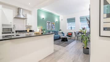 A modern apartment with a kitchen, living area, and dining space.