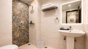 A modern bathroom with a marble shower wall, a sink with a mirror, and a toilet. - OPO Essential Alpino (New Delhi)