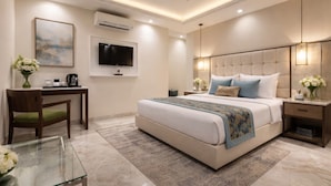 A modern bedroom with a large bed, a desk, and a television. - OPO Essential Alpino (New Delhi)