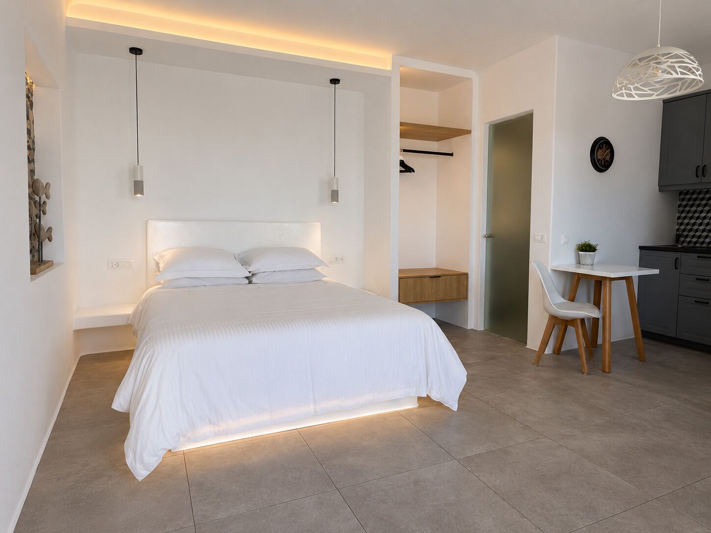 A modern bedroom with a large bed, bedside tables, a desk, and a chair.