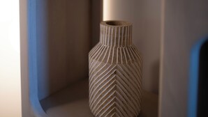 A vase with a ribbed texture placed on a shelf. - New Farmhouse TENUTA MARELLA immersed in the Green at the gates of Rome (Lazio)