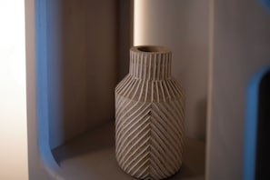 Un florero de textura acanalada sobre una estantería.