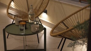 A round glass table with a bottle, two cups, and a glass of water. - AIORA Urban Oasis - Rooftop Jacuzzi & BBQ (Thessaloniki)