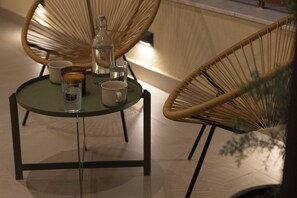 A round glass table with a bottle, two cups, and a glass of water. - AIORA Urban Oasis - Rooftop Jacuzzi & BBQ (Thessaloniki)