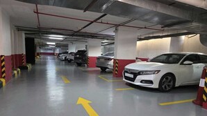 A multi-level parking garage with cars parked and directional arrows on the floor. - Vercure Jeddah Alhamra Hotel (Jeddah)