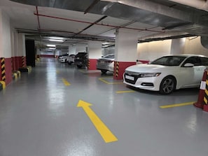 A multi-level parking garage with cars parked and directional arrows on the floor. - Vercure Jeddah Alhamra Hotel (Jeddah)