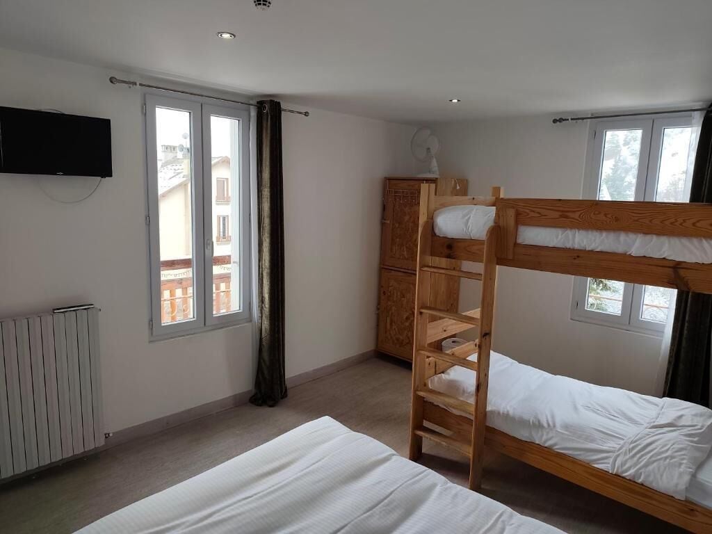 Una habitación con literas, televisión, armario y ventana.