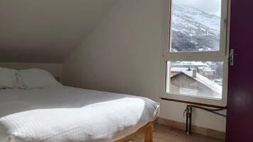 Ein Schlafzimmer mit Bett, Fenster und Tür.