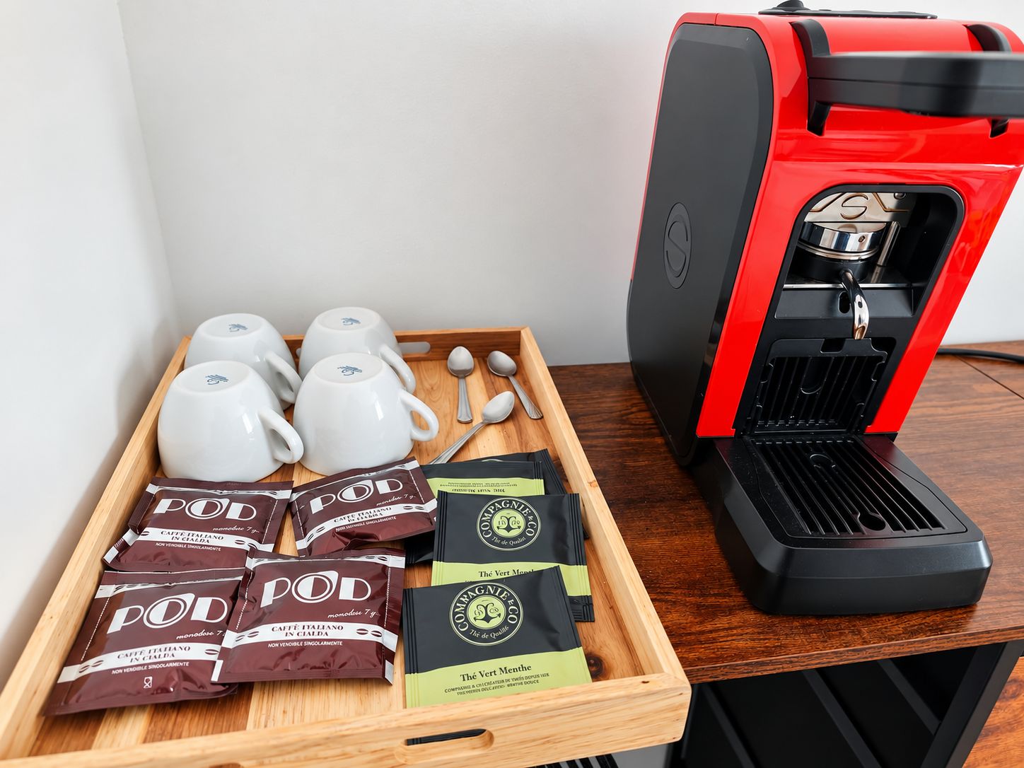 Una cafetera con un surtido de cápsulas de café y tazas.