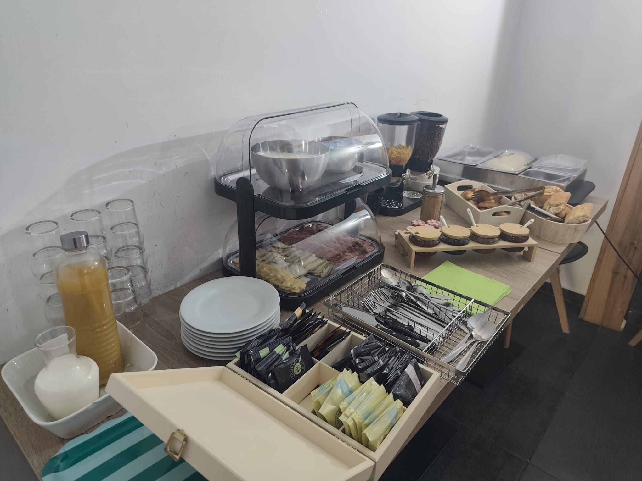 Een buffetopstelling met verschillende gerechten, bestek en bakken.