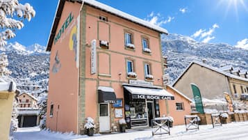 Un hôtel doté d’un bar et d’un restaurant situés au rez-de-chaussée, entouré de montagnes enneigées.