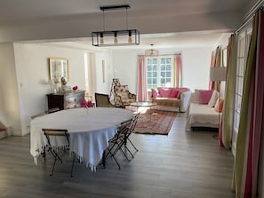A dining area with a table and chairs, a sofa, a chair, a rug, and a window with curtains. - Maison au calme à La Garde, entre mer et Provence (La Garde)