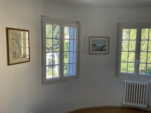 A room with two windows, a radiator, and two framed pictures on the wall. - Maison au calme à La Garde, entre mer et Provence (La Garde)