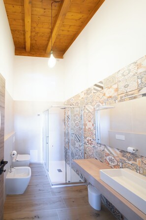 A bathroom with a wooden ceiling, a shower, a bidet, and a sink with a tiled backsplash. - New Farmhouse TENUTA MARELLA immersed in the Green at the gates of Rome (Lazio)