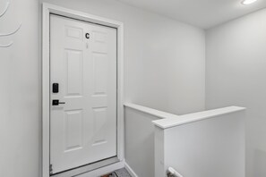 A white door with a keypad lock and a letter 'C' on it. - Downtown 3BR Top-Floor Condo w/ Balcony (Ocean City)
