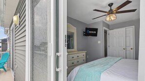 Une chambre à coucher avec un lit, une commode et un ventilateur de plafond.