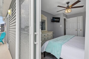 A bedroom with a bed, dresser, and a ceiling fan. - Downtown 3BR Top-Floor Condo w/ Balcony (Ocean City)