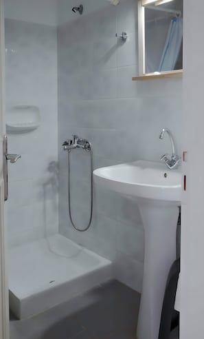 Un bagno con vasca, lavabo e doccia.